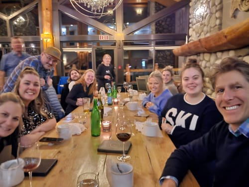 Reviewer and friends dining together inside a rustic ski lodge.