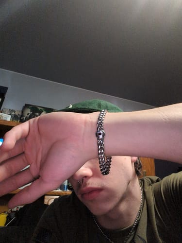 Reviewer wearing the silver-colored Evil Eye Bracelet with a skull detail on their wrist.