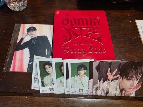 Customer's STRAY KIDS Blu-Ray gift set, showing the red case alongside the included postcards and fanned-out photocards.