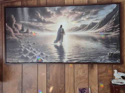 Customer's framed 'Jesus walking on the Water' wall art hanging on a wood-paneled wall.