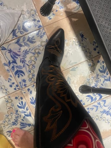 Customer wearing a black Corky's Just In Case Boot, showing a close-up of the detailed golden embroidery.