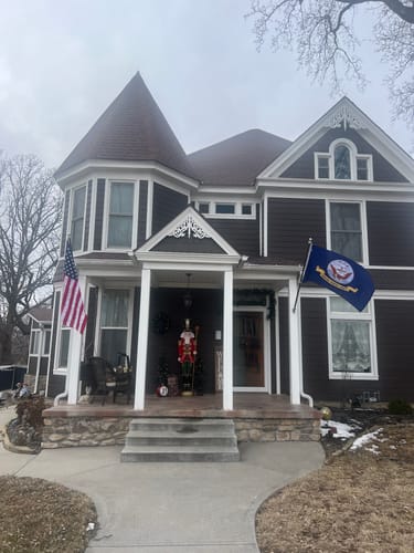 Customer's Prestige House Flag Pole with an American flag mounted on the front porch of a large house.