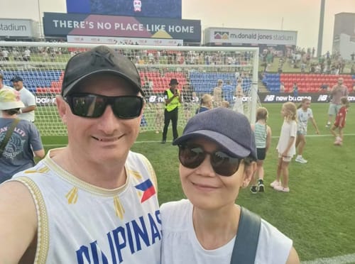 Customer wearing the white Philippines 'Luzviminda' Custom Basketball Jersey at an outdoor stadium.