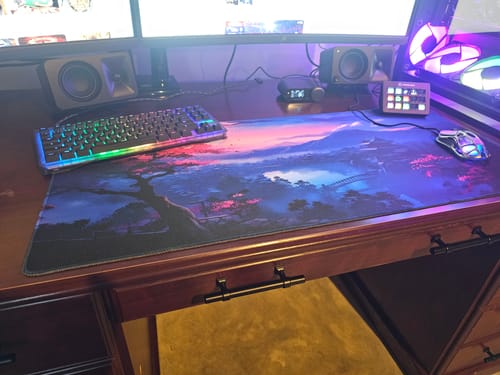 Reviewer's Yozakura mouse pad on a wood desk, part of a complete, colorful gaming setup.