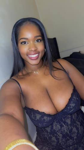 Reviewer in a close-up photo wearing the black Stretch Lace Midi Dress, showing the supportive sweetheart neckline.