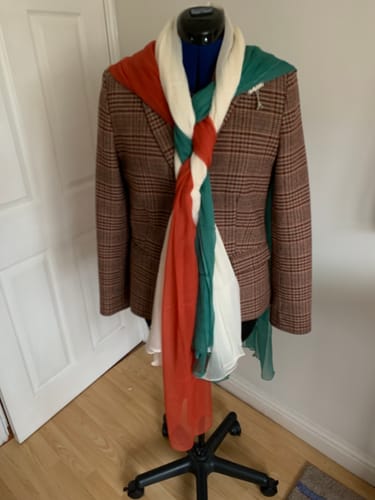 Reviewer's three crepe fabrics in orange, green, and cream styled as a braided scarf on a dress form.