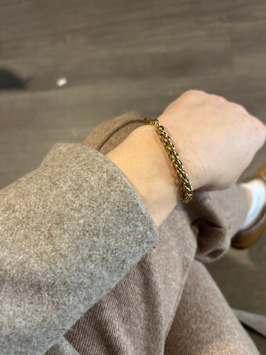 Reviewer showing their favorite gold chain bracelet on their wrist, part of a 5-piece set.