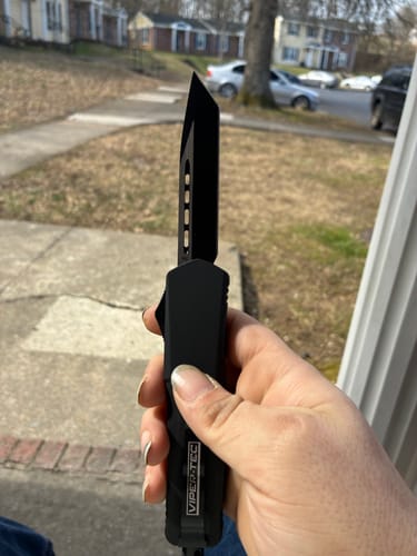 Customer holding the black VIPER TEC GHOST OTF knife with its tanto blade extended.