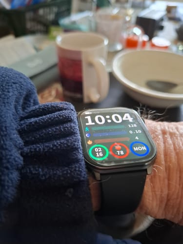 Customer's close-up of a black smartwatch on their wrist, showing the time and activity metrics on the screen.