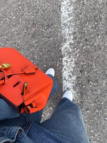 Customer carrying their bright orange Warkin Bag, viewed from above.