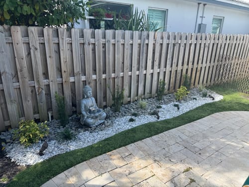 Customer's newly planted Liriope plants used as a decorative border along a fence and patio.