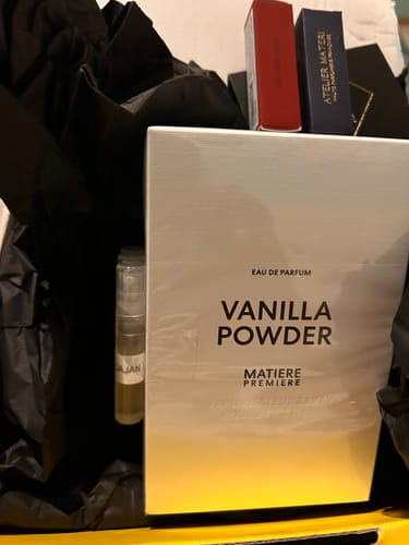Il recensore mostra la scatola del profumo Vanilla Powder con la sua confezione e alcuni campioncini.