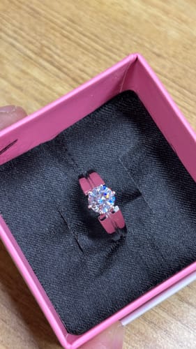 Customer's close-up of the elegant Silver Gallant Band with a zircon, presented in its pink and black box.