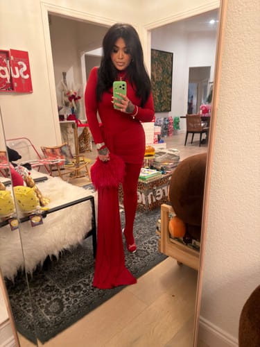Reviewer taking a full-length mirror selfie in the red, form-fitting Naked Closed Toe Jumpsuit.