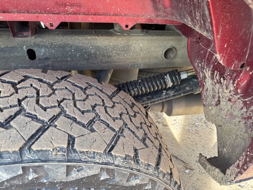 Customer's close-up of the black RoadActive Suspension HD Kit installed on their dirty truck.