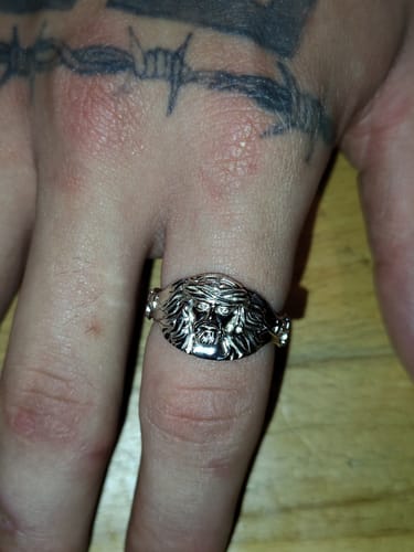Close-up of a customer wearing the shiny JESUS RING on their index finger.