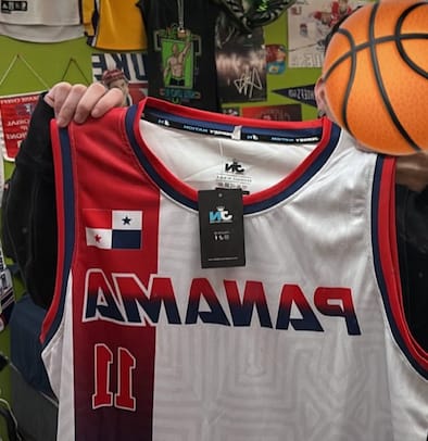 Reviewer holding the front of a white Panama Heritage Custom Basketball Jersey, showing the flag and number 11.