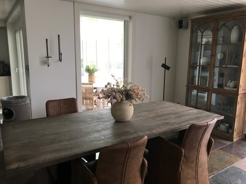 Recensent toont het Wax-arrangement in een crèmekleurige vaas op een houten eettafel.