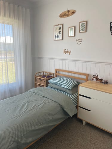 Customer's 'Ride The Wave' art print in a wood frame, hung as part of a gallery wall in their son's bedroom.