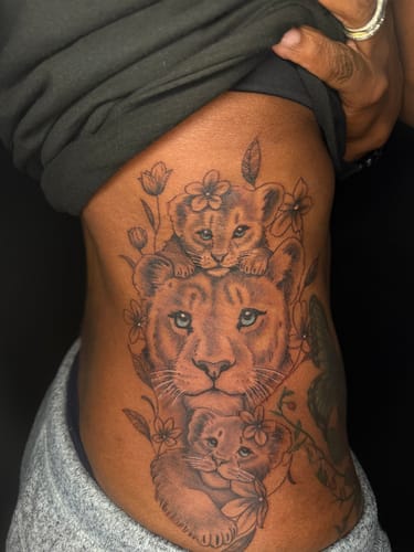 Customer's large, detailed tattoo of a lioness and two cubs on their side, completed using the numbing spray.