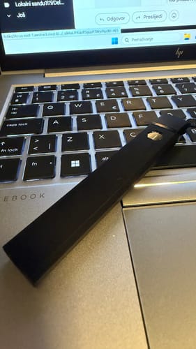 Customer's black ROLLZ THCA Vape resting on a laptop keyboard.