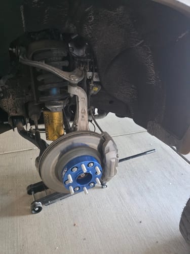 Customer's blue 1.5" Hubcentric Wheel Spacer installed on a truck's hub assembly with the wheel removed.