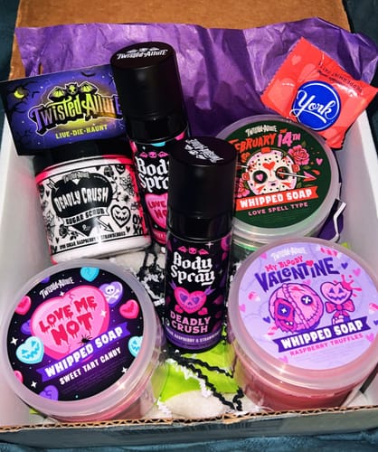 Customer's Love Me Not Whipped Soap in a clear tub, displayed in a box with other colorful bath products.