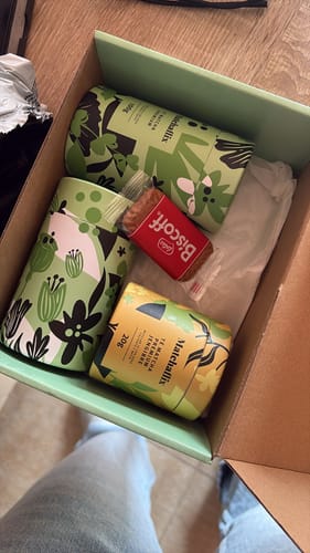 Reseñador mostrando varios botes de Té Matcha Premium dentro de su caja de envío.