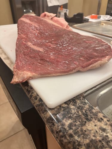 Customer's raw USDA Prime Brisket on a white cutting board before trimming.