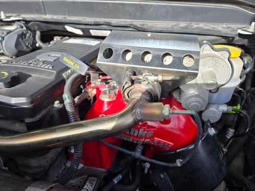 Customer's installed red Monster-Ram Intake in a Cummins engine bay, showing the upgraded part.