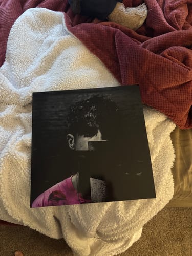 Customer's custom vinyl record with personalized cover art resting on a soft white blanket.