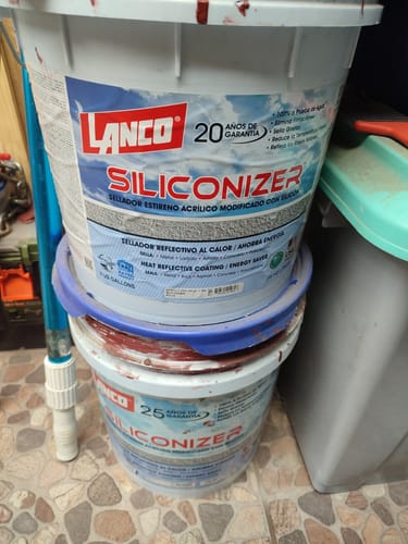 Cliente muestra dos tinetas apiladas del sellador de techos Lanco Siliconizer.