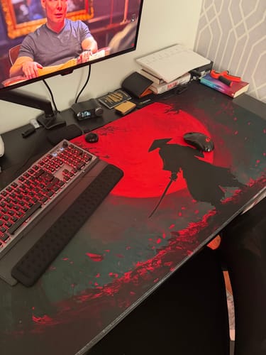 Customer's desk setup showing the Red Blade pad's vibrant red samurai design with a keyboard on it.