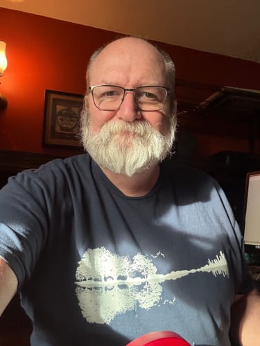 Reviewer wearing the navy Forest Guitar T-Shirt, showing the white graphic of a guitar made of trees and their reflection.