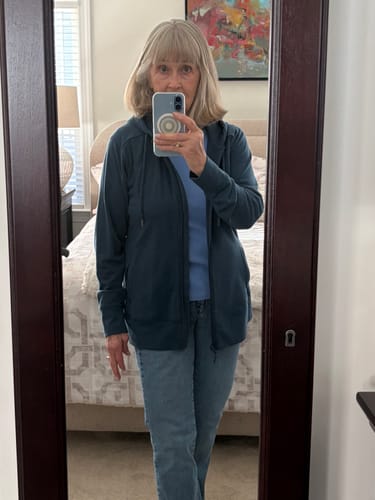 Reviewer showing the relaxed fit of their blue Ryann Hoodie, worn unzipped over a t-shirt and jeans.