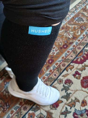 Customer wearing the black Performance Eucalyptus Compression Socks, showing the fit with the blue 'HUSHED' brand tag visible.