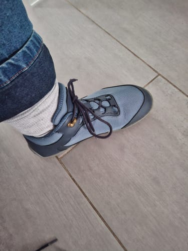 Nahaufnahme des Fußes eines Kunden, der einen hellblauen Brave Ⅰ Barfußschuh drinnen trägt.