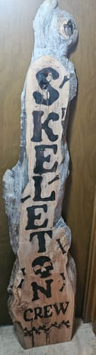 Customer's rustic Halloween sign made with Scorch Paint on live edge wood. It reads 'Skeleton Crew' with spooky graphics.