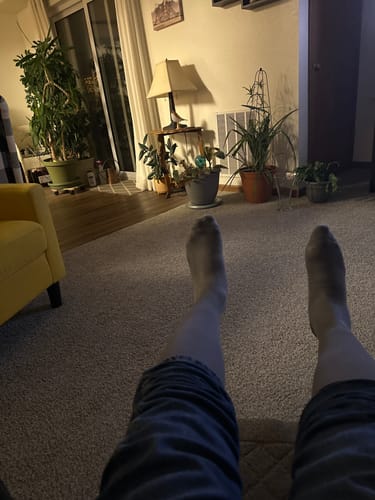Reviewer's view of their legs propped up while wearing the sheer Performance Eucalyptus Compression Socks.