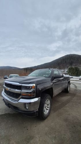 Customer's dark Chevy Silverado 1500 with a taller stance after installing the 3" Front Leveling Lift Kit in a parking lot.