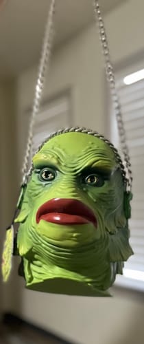 Close-up of a customer's green Creature from the Black Lagoon Monster Bag, showing its detailed face and chain strap.