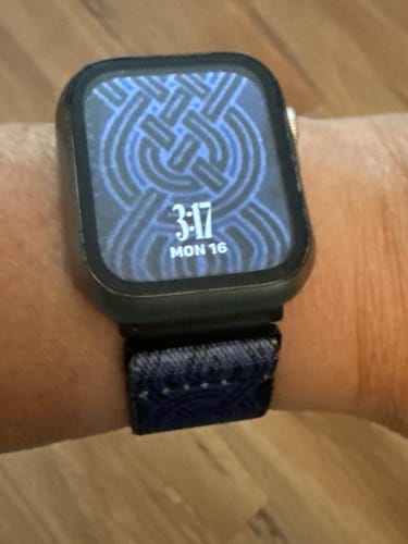 Close-up of a reviewer's wrist wearing the dark blue Unbreakable Bonds Watchband+ on a smartwatch.