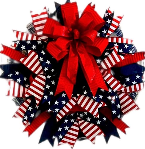 Customer's patriotic wreath crafted with navy and white star ribbon and topped with a large red bow.