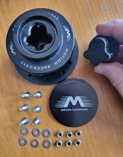 Customer's Motion Raceworks quick release hub kit, showing the black interlocking parts, horn cap, and included stainless hardware.