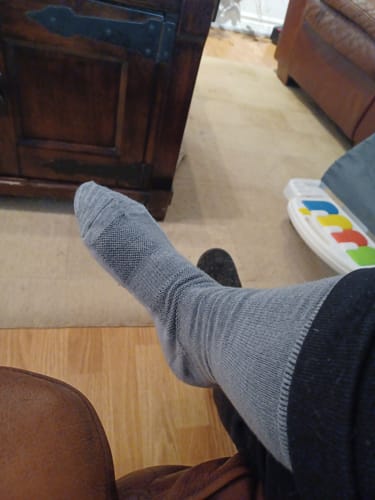 Reviewer wearing a long, grey sock from the bundle, showing the fit on their leg and foot.