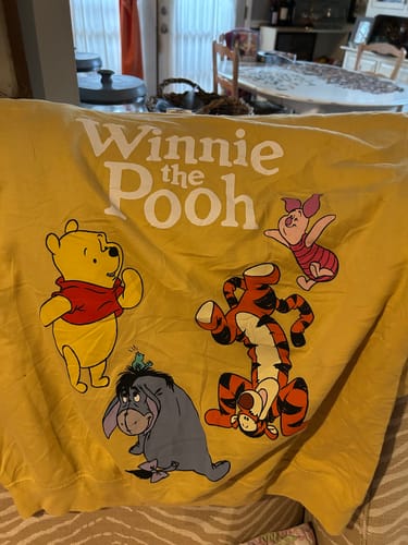 Customer's yellow cartoon sweatshirt featuring Winnie the Pooh, Piglet, Tigger, and Eeyore.