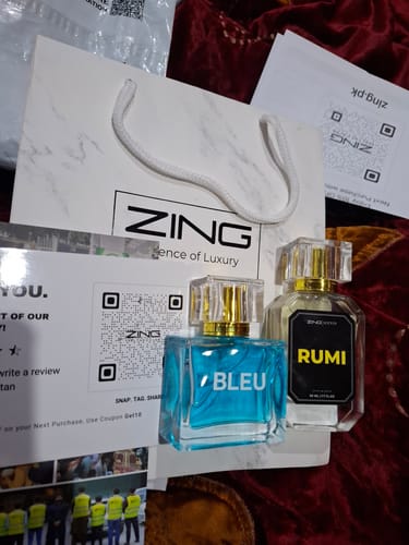 Reviewer's two ZING fragrances, "BLEU" and "RUMI", displayed with the brand's packaging.
