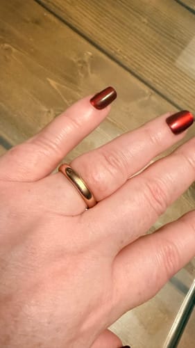Customer's hand wearing the polished, rose gold-colored Seren ring on their finger.