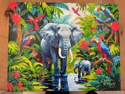 Reviewer's completed painting from the Jungle Elephants kit, featuring a mother elephant and calf by water in a vibrant jungle.