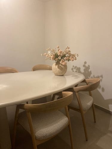 Recensent toont het crèmekleurige Wax Arrangement in een mooie vaas op een eettafel.